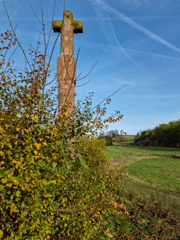 Ablasskreuz mit Wehrkirche in der Ferne